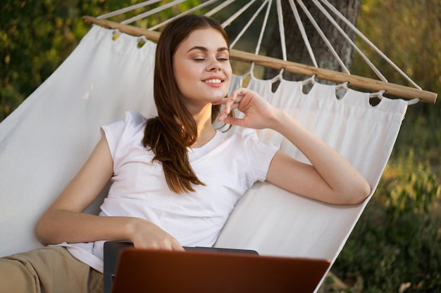 Foto mujer joven usando teléfono móvil mientras está sentada al aire libre