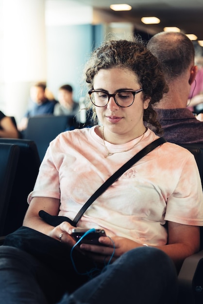 Foto mujer joven usando teléfono móvil mientras está sentada en el asiento