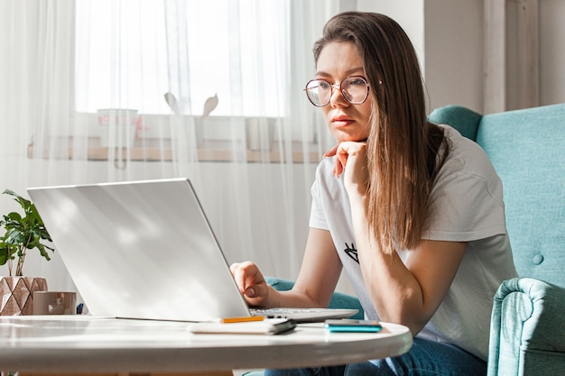 Mujer joven, utilizar la computadora portátil, para trabajar, casa