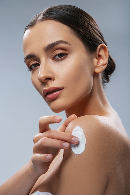 Mujer joven, utilizar, cosméticos, para, cuerpo colección de foto