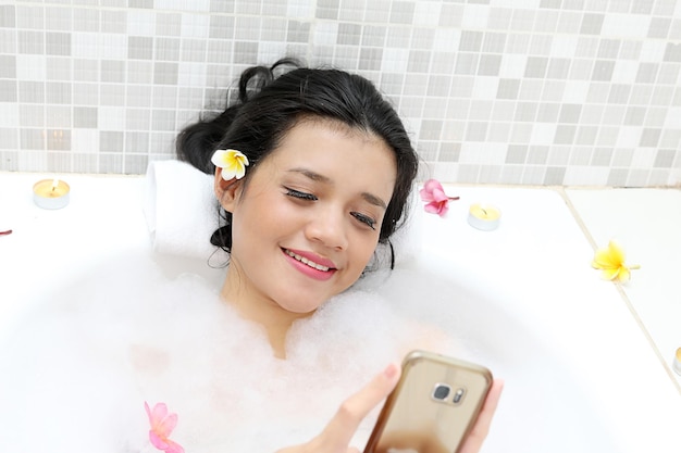 mujer joven, utilizar, un, teléfono móvil, en, bañera