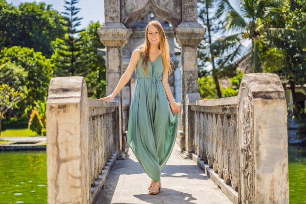 Mujer joven vestida en el Palacio del Agua Soekasada Taman Ujung Ruinas en la isla de Bali en Indonesia Increíble arquitectura antigua Fondo de viajes y vacaciones