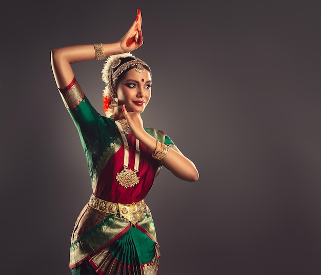 Mujer joven vestida con traje de danza tradicional india muestra la belleza de la danza clásica bharatanatyam