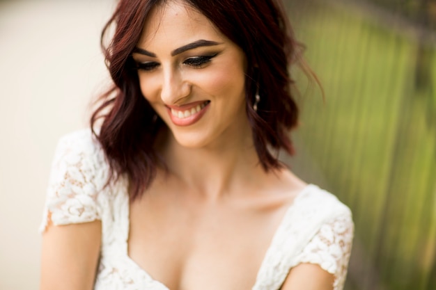 Mujer joven en vestido blanco en la calle