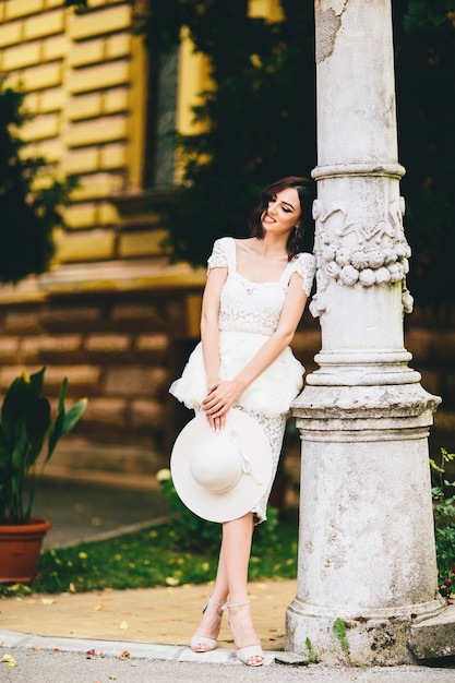 Foto mujer joven en vestido blanco en la calle