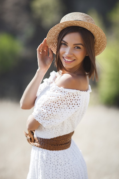 Mujer joven en un vestido blanco y sombrero