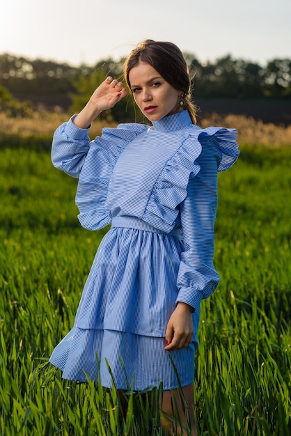 Mujer joven en vestido de rayas azul y blanco