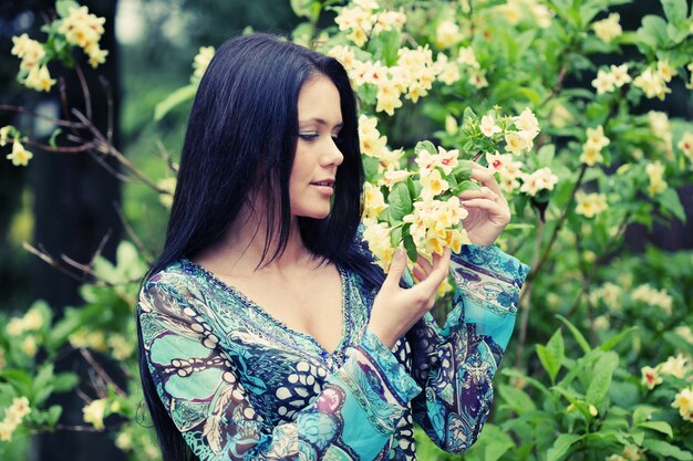 mujer joven en vestido relajante en el jardín