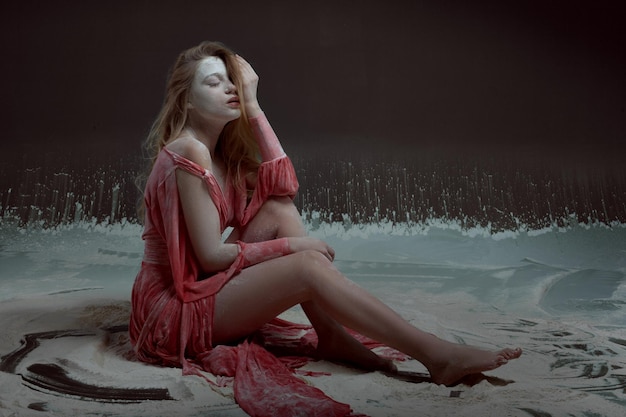 Foto mujer joven, en, vestido rojo, sentado sobre el piso, en, harina