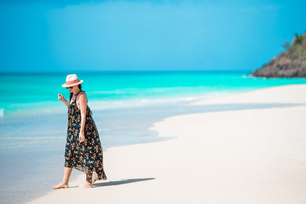 Mujer joven en vestido verde en la playa