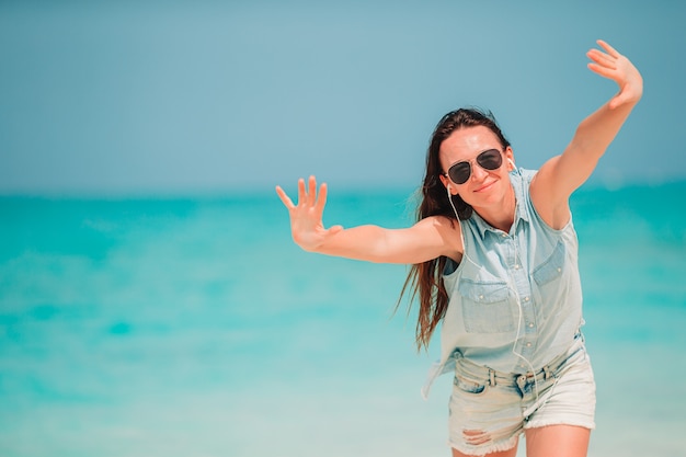 Mujer joven en vestido verde en la playa