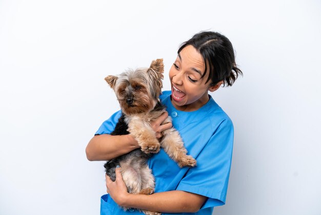 Mujer joven veterinaria con perro aislado sobre fondo blanco celebrando una victoria