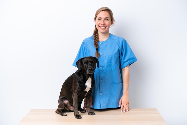 Mujer joven veterinaria con perro aislado sobre fondo blanco con expresión feliz
