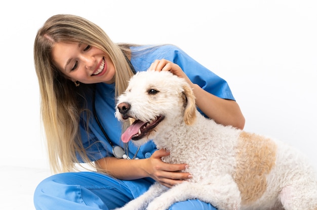 Mujer joven veterinario con perro sentado en el suelo