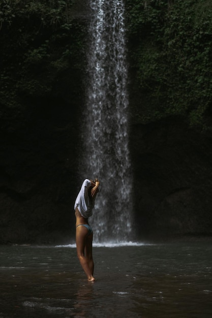 mujer joven viaja por la isla tomando fotos en una cascada