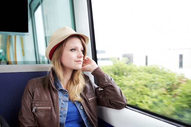 Mujer joven viaja en tren en Copenhague DK