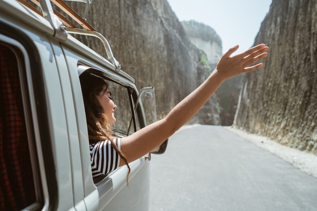 Mujer joven en viaje por carretera en la playa