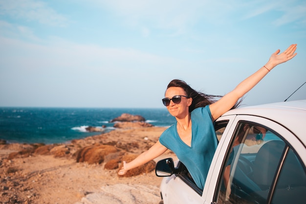 Mujer joven en viaje de vacaciones en coche. Vacaciones de verano y concepto de viaje en coche. Viajes familiares.