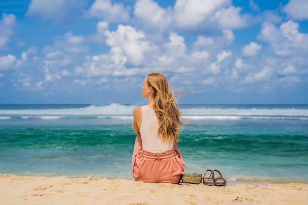 Mujer joven viajera en la increíble playa de Melasti con agua turquesa Isla de Bali Indonesia