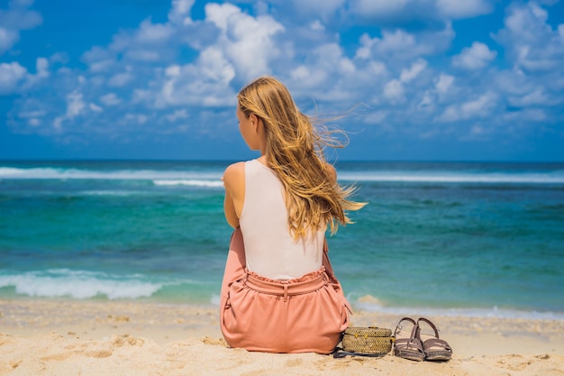 Mujer joven viajera en la increíble playa de Melasti con agua turquesa Isla de Bali Indonesia