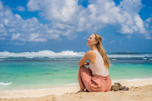 Mujer joven viajera en la increíble playa de Melasti con agua turquesa Isla de Bali Indonesia