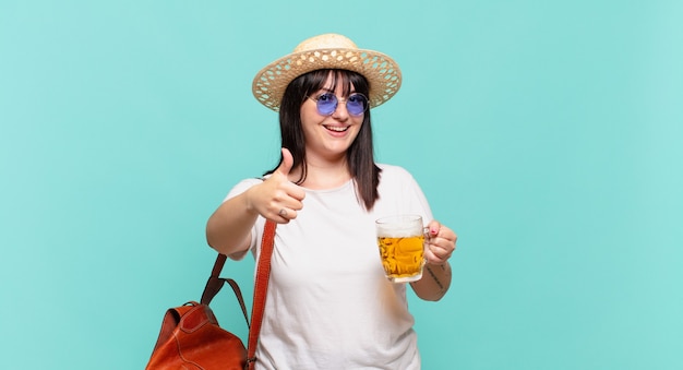 Mujer joven viajera que se siente orgullosa, despreocupada, segura y feliz, sonriendo positivamente con los pulgares hacia arriba