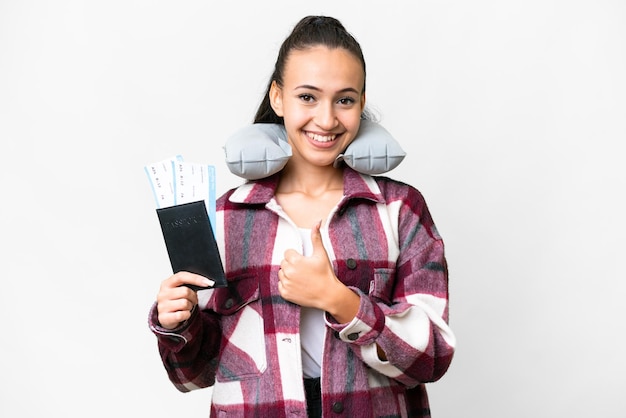 Mujer joven viajera sosteniendo un pasaporte sobre fondo blanco aislado dando un gesto de aprobación