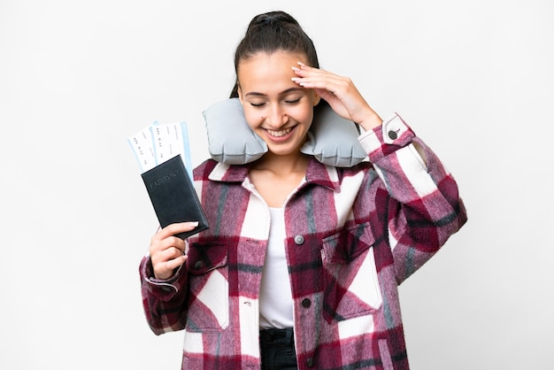 Mujer joven viajera sosteniendo un pasaporte sobre fondo blanco aislado riendo