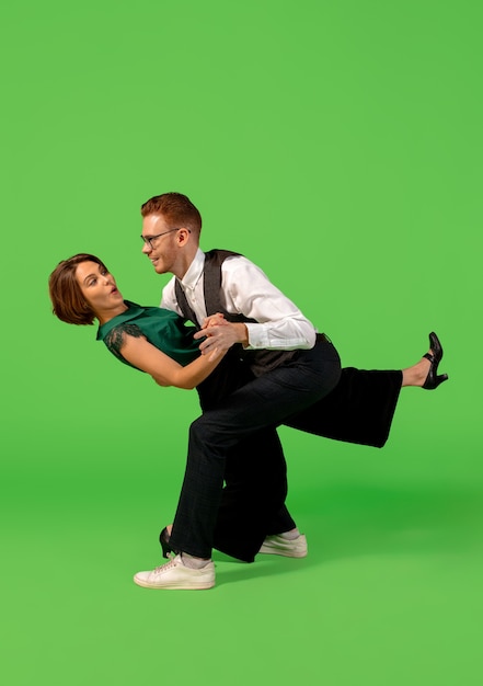 Mujer joven a la vieja usanza bailando aislado sobre fondo verde