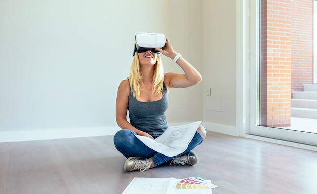 Mujer joven viendo la decoración de su casa con gafas de realidad virtual