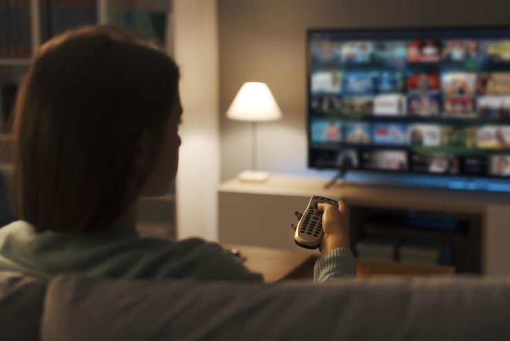 Foto mujer joven viendo video a pedido en su televisor