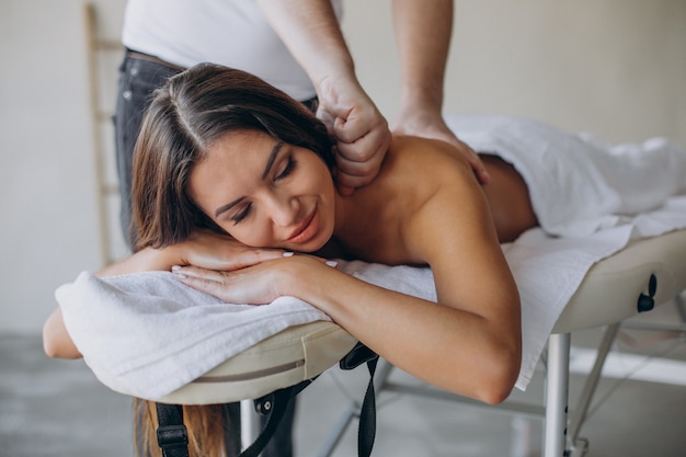 Mujer joven visitando masajista en el centro de spa