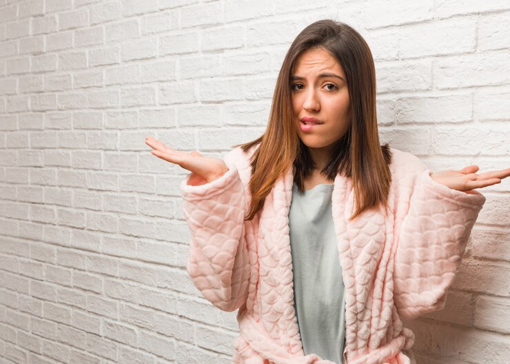 Foto mujer joven vistiendo pijama confundido y dudoso
