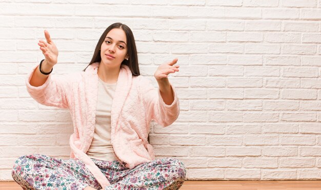 Foto mujer joven vistiendo pijama invitando a venir