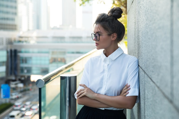 Mujer joven vistiendo ropa casual elegante en las calles de la ciudad moderna