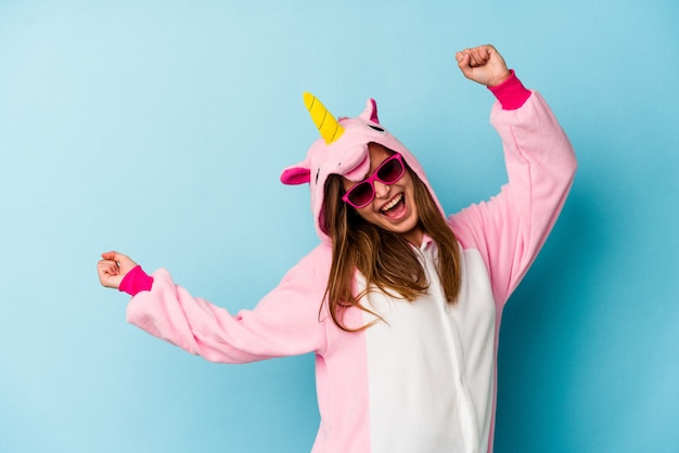 Mujer joven vistiendo un traje de unicornio con gafas de sol aislado