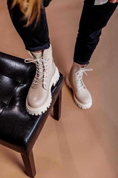 Mujer joven en zapatos con cordones de cuero de moda con estilo beige. Colección de moda de zapatos de otoño para mujer. Primer plano de piernas femeninas en zapatos.