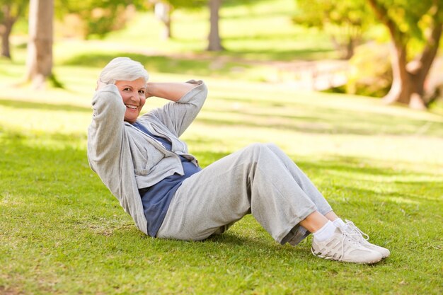 Mujer jubilada haciendo su estira en el parque