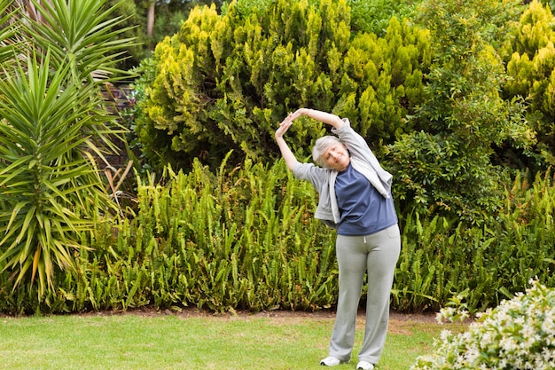 Mujer jubilada haciendo sus streches en el jardín