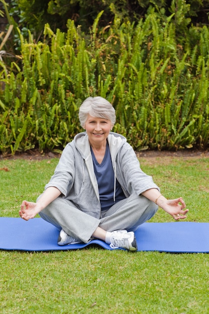 Foto mujer jubilada practicando yoga en el jardín