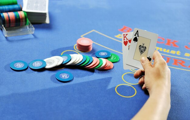 mujer juega al juego de cartas black jack en el casino en la mesa azul