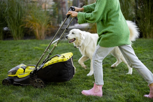 Mujer juega con su perro en el patio trasero mientras trabaja en el jardín