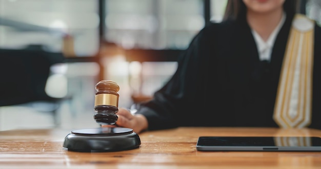 Foto mujer juez mano sosteniendo mazo para golpear el bloque de sonido en la sala del tribunal