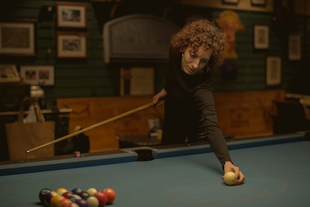 Mujer jugando al billar en un bar