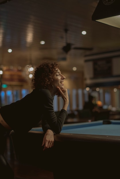 Mujer jugando al billar en un bar