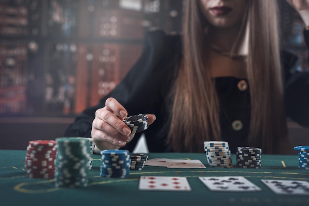 Mujer jugando al póquer y hace una apuesta aumenta con fichas de casino