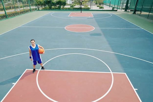 Mujer jugando baloncesto solo