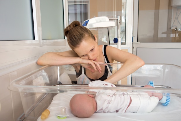 Mujer jugando con bebe en cuna