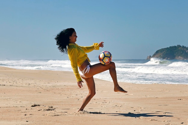 Mujer jugando a la pelota en la playa