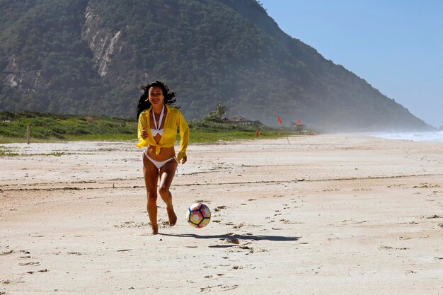 Mujer jugando a la pelota en la playa